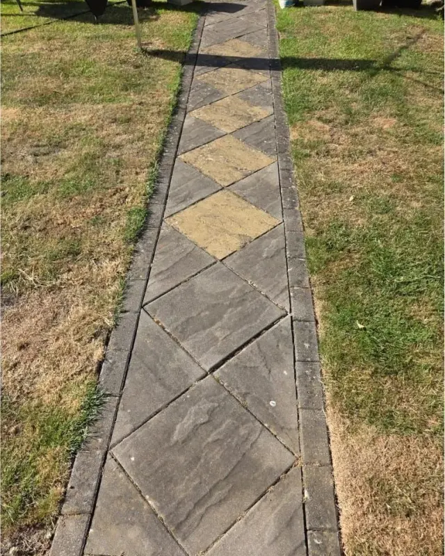 Grey slab path with dull diamond pattern before cleaning
