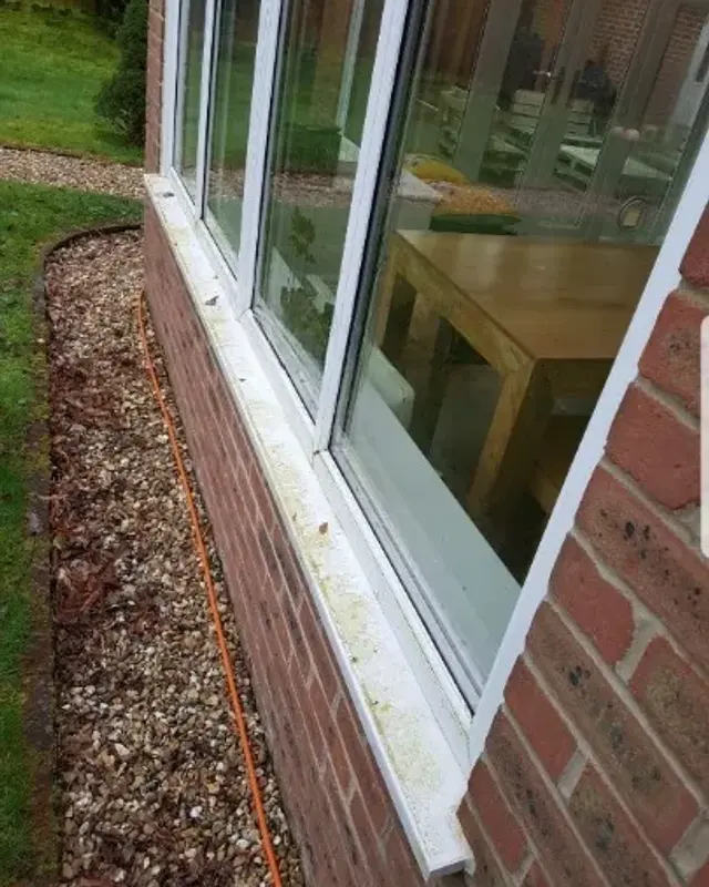 Patio door frame and sill marked with dirt before cleaning
